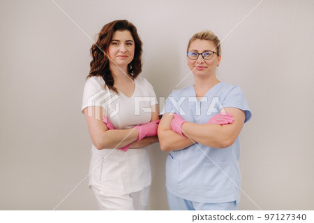 Portrait of two qualified cosmetologists-women smiling confidently in a medical center Portrait of two qualified cosmetologists-women smiling confidently in a medical center 97127340