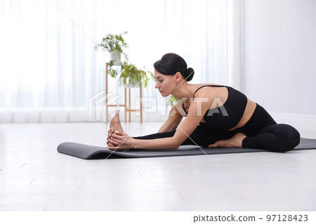 Professional young acrobat practicing yoga at home 97128423