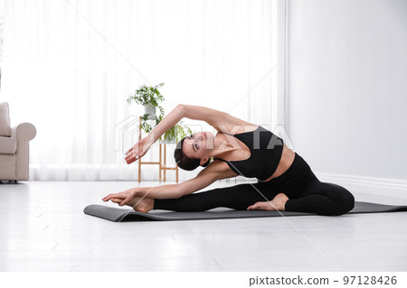 Professional young acrobat practicing yoga at home 97128426