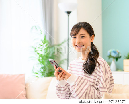 Woman operating a smartphone Woman operating a smartphone 97128671