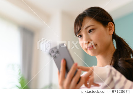 Woman operating a smartphone 97128674
