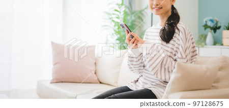 Woman operating a smartphone Woman operating a smartphone 97128675