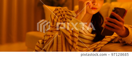 A woman watching a smartphone 97128685