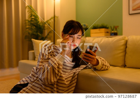 A woman watching a smartphone 97128687