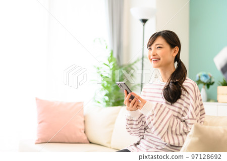 Woman operating a smartphone Woman operating a smartphone 97128692