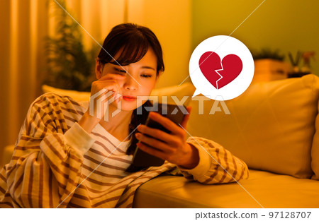 A woman watching a smartphone A woman watching a smartphone 97128707