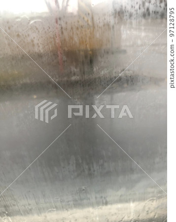Scenery seen from the inside of the car with the window clouded by condensation 97128795