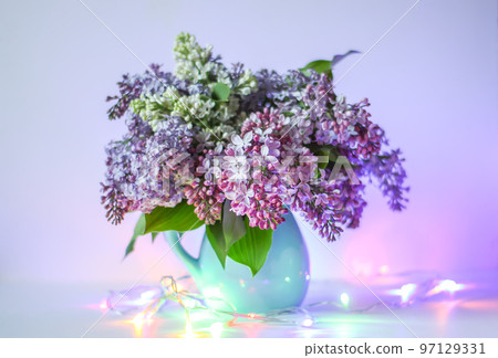 Beautiful bouquet of fragrant purple flowers in blue ceramics vase on light background. Syringa vulgaris or lilacs plant. Beautiful bouquet of fragrant purple flowers in blue ceramics vase on light background. Syringa vulgaris or lilacs plant. 97129331