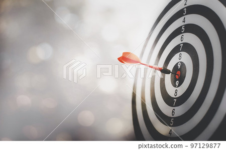 Close up shot of the dart arrow hit on bullseye, red dart arrow hitting in the target center of dartboard Target hit in the center, challenge in business marketing, Target and goal as concept. Close up shot of the dart arrow hit on bullseye, red dart arrow hitting in the target center of dartboard Target hit in the center, challenge in business marketing, Target and goal as concept. 97129877
