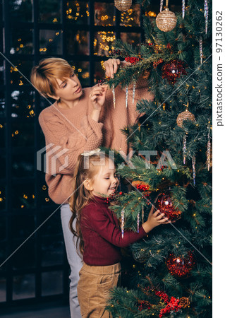 Mom and daughter decorate the Christmas tree Mom and daughter decorate the Christmas tree 97130262