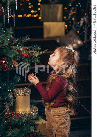 Girl decorates the Christmas tree Girl decorates the Christmas tree 97130263