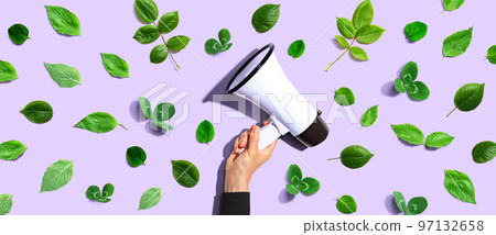 Person holding a megaphone with green leaves 97132658