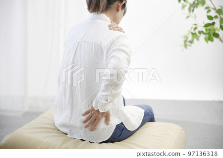 A middle-aged woman who is unwell due to shoulder pain 97136318