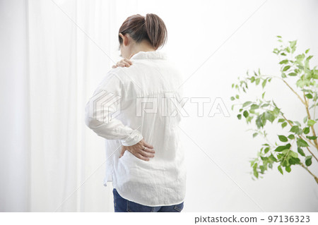 A middle-aged woman who is unwell due to shoulder pain 97136323