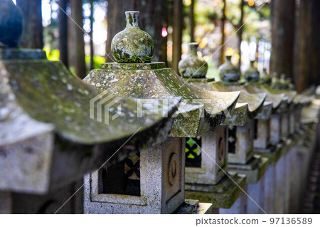 Japanese stone toro lanterns at shrine entrance 97136589