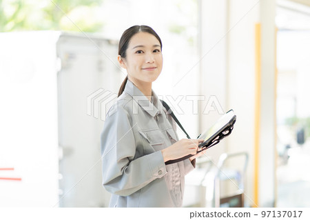 Young female worker working in distribution warehouse 97137017