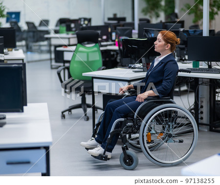 Caucasian woman wheelchair in open space office. 97138255