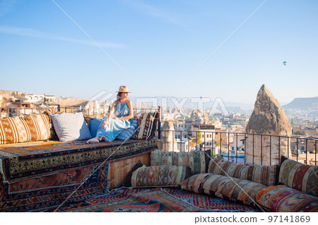 Young woman in dress on the roof with amazing view of Cappadocia in Turkey 97141869