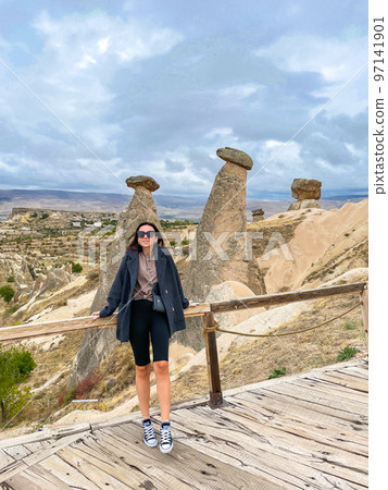 Young happy woman on vacation in Cappadocia. Cave formations. 97141901