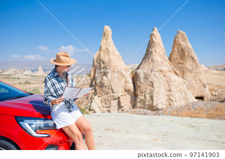 Woman road tripping and looking at the map. Travel by car 97141903