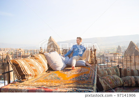 Happy young man on the roof in Cappadocia, Turkey 97141906