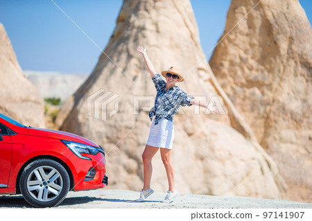 Young happy woman on vacation by car in Cappadocia. Cave formations. 97141907