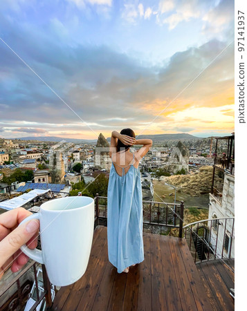 Young woman in dress on the roof with amazing view of Cappadocia in Turkey 97141937