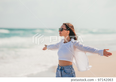 Young happy woman on the beach enjoy her summer vacation. Girl is happy and calm in her stay on the beach 97142063