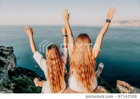 Sea family vacation together, happy mom and teenage daughter hugging and smiling together over sunset sea view. Beautiful woman with long hair relaxing with her child. Concept of happy friendly family Sea family vacation together, happy mom and teenage daughter hugging and smiling together over sunset sea view. Beautiful woman with long hair relaxing with her child. Concept of happy friendly family 97142509