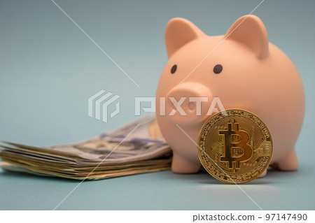 Pink piggy bank, stuck of dollars and bitcoin coin on a blue background. Pink piggy bank, stuck of dollars and bitcoin coin on a blue background. 97147490