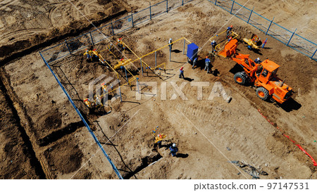 Aerial view excavator and construction workers working on construction site in open field. Pipe 97147531