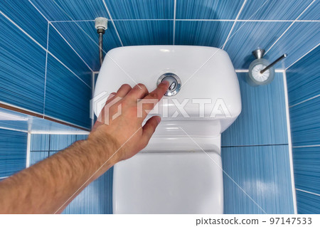 Man presses toilet button with his hand and drains water in toilet. First-person view. Interior Man presses toilet button with his hand and drains water in toilet. First-person view. Interior 97147533