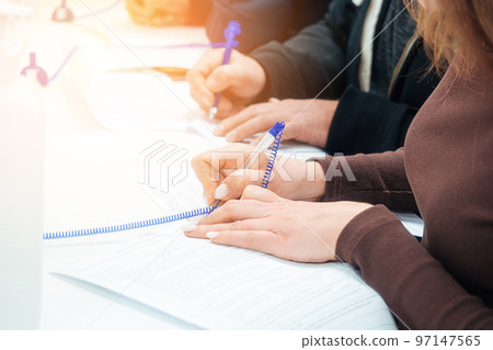 Woman fills out blank application form at table or signs contract. Hands of people with close-up 97147565