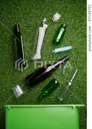 Separate collection of glass garbage. Recyclable glass waste on green grass background. 97149701