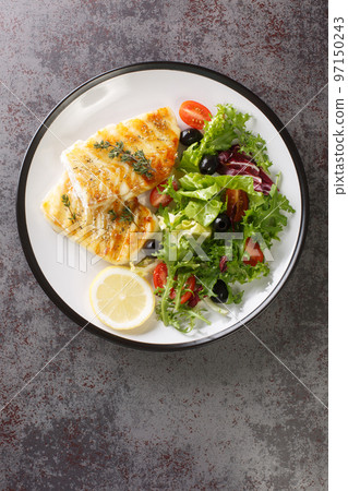 Grilled cod with fresh salad tomatoes, olives, lettuce mix close-up in a plate. Vertical top view Grilled cod with fresh salad tomatoes, olives, lettuce mix close-up in a plate. Vertical top view 97150243