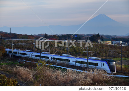 Limited express Azusa running along the silhouette of Mt. Fuji and the Japanese pampas grass 97150628