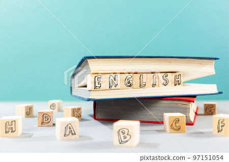 English Language Day. On the table there are books and wooden cubes with the inscription english. Turquoise background. The concept of learning foreign languages English Language Day. On the table there are books and wooden cubes with the inscription english. Turquoise background. The concept of learning foreign languages 97151054