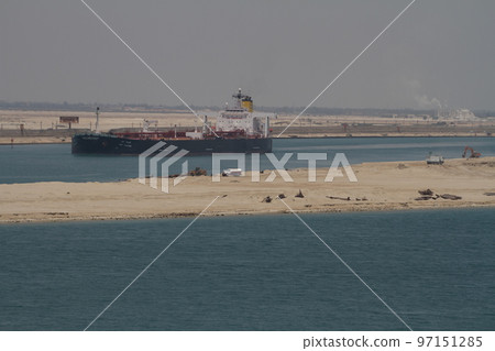 A large cargo ship making its return trip along the central strip of the Suez Canal. 97151285
