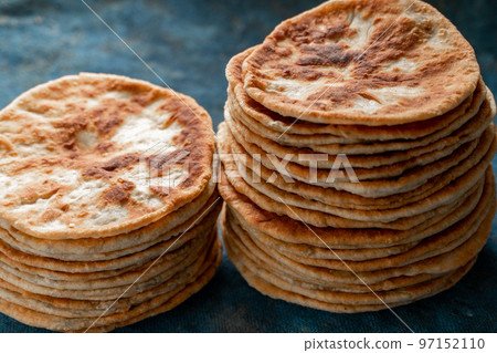Flatbread lavash, chapati, naan, heap of tortilla on a blue background Homemade flatbread stacked. 97152110