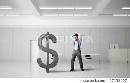 Determined banker man in modern office interior breaking dollar figure 97152407
