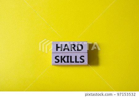Hard skills symbol. Wooden blocks with words Hard skills. Beautiful yellow background. Businessman hand. Business and Hard skills concept. Copy space 97153532