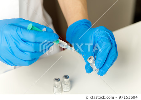 doctor hands injecting a syringe needle into a small bottle with a vaccine or drug assign virus or flu. 97153694