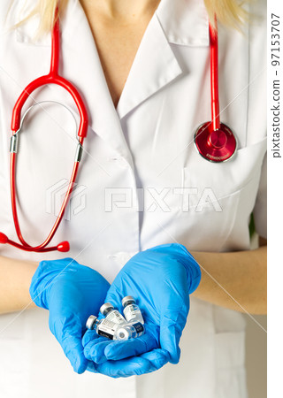 Estonia, Tallinn, 09.01.2021 doctor holds in hands small ampoules of Covid-19 vaccine by Pfizer and BioNTech 97153707
