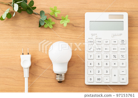 Calculator and outlet plug on the desk, wood grain background Calculator and outlet plug on the desk, wood grain background 97153761
