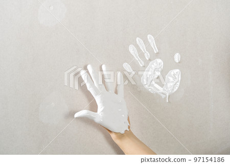Hand print made with white paint on drywall. painter have fun 97154186