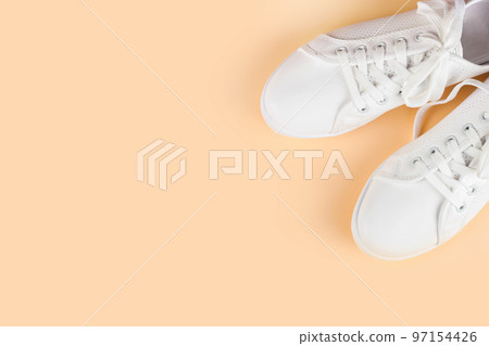 White sneakers on coral background. copy space. 97154426