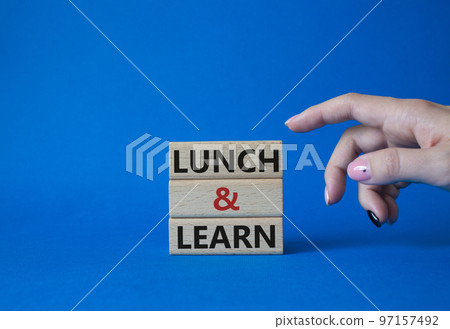 Lunch and learn symbol. Concept words Lunch and learn on wooden blocks. Beautiful blue background. Businessman hand. Business and Lunch and learn concept. Copy space 97157492