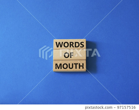 Words of mouth symbol. Concept word Words of mouth on wooden blocks. Beautiful blue background. Business and Words of mouth concept. Copy space 97157516