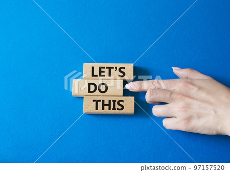 Let's do this symbol. Concept word Let's do this on wooden blocks. Businessman hand. Beautiful blue background. Business and Let's do this concept. Copy space Let's do this symbol. Concept word Let's do this on wooden blocks. Businessman hand. Beautiful blue background. Business and Let's do this concept. Copy space 97157520