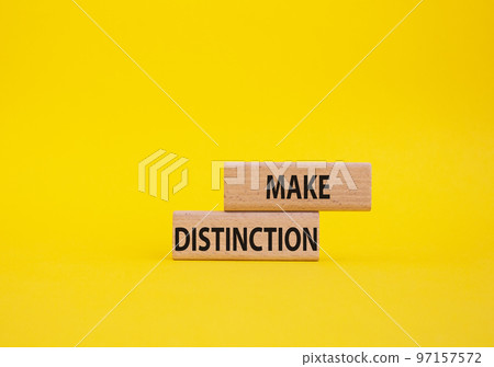 Make distinction symbol. Concept words make distinction on wooden blocks. Beautiful yellow background. Business and make distinction concept. Copy space. 97157572
